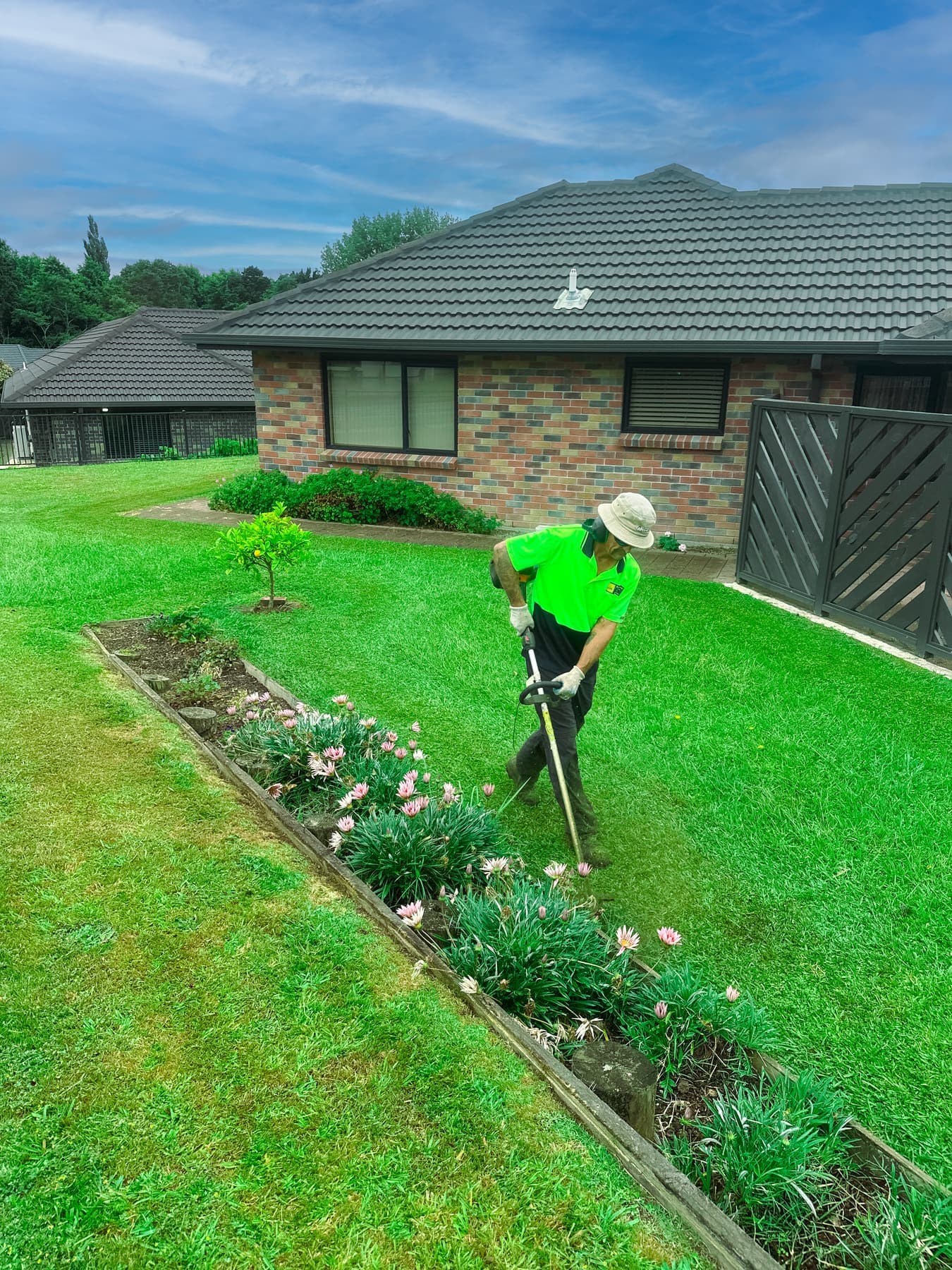 Team member edging a garden bed with spade