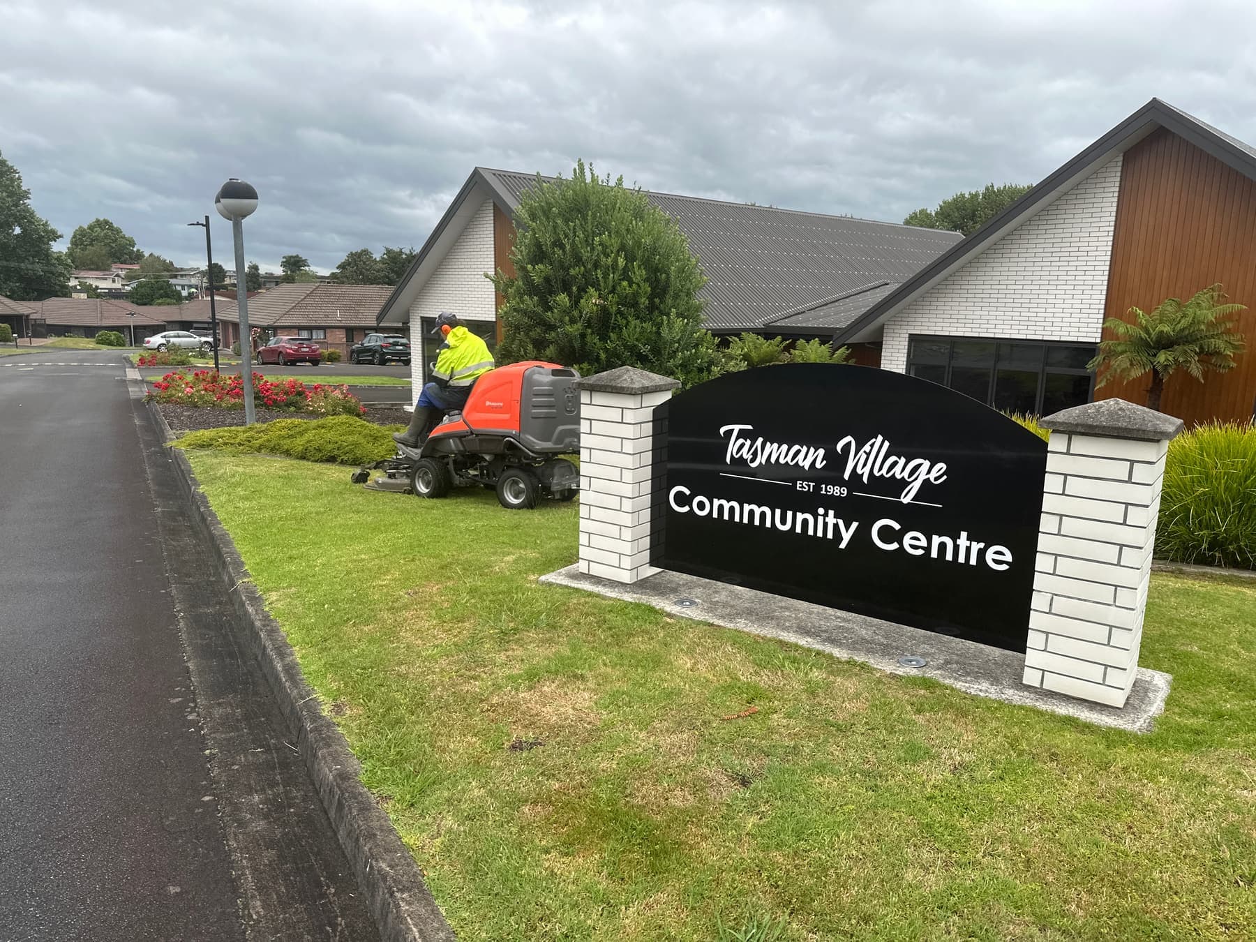 Tasman Village Community Centre sign with mowing in progress